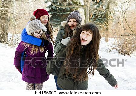 Stock Image - Caucasian girls playing in snowy field. Fotosearch
