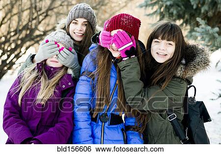 Stock Photograph - Caucasian girls playing in snowy field. Fotosearch