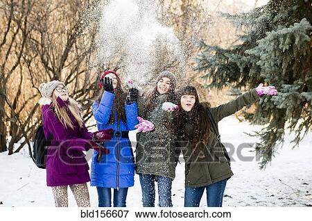 Caucasian girls throwing snow in field View Large Photo Image Stock Photo - Caucasian girls throwing snow in field. Fotosearch