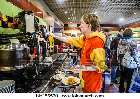 Stock Image - Caucasian woman getting breakfast in cafeteria. Fotosearch