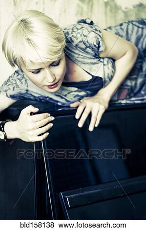 Caucasian woman laying on upright piano View Large Photo Image Stock Photo - Caucasian woman laying on upright piano. Fotosearch