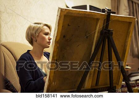 Caucasian woman painting on canvas in living room View Large Photo Image Stock Image - Caucasian woman painting on canvas in living room. Fotosearch