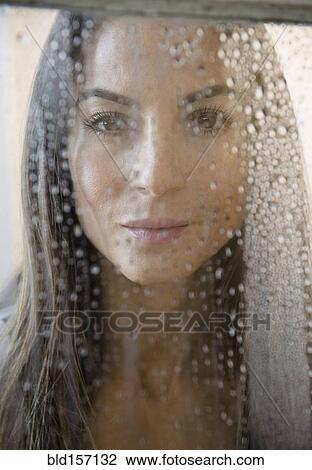 Caucasian woman peering through wet window View Large Photo Image Stock Image - Caucasian woman peering through wet window. Fotosearch