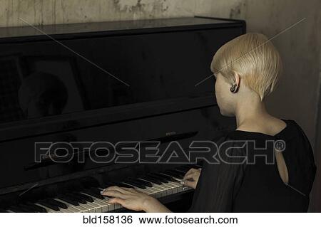 Stock Photograph - Caucasian woman playing piano. Fotosearch