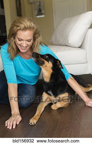 Caucasian woman playing with dog in bedroom View Large Photo Image Stock Image - Caucasian woman playing with dog in bedroom. Fotosearch