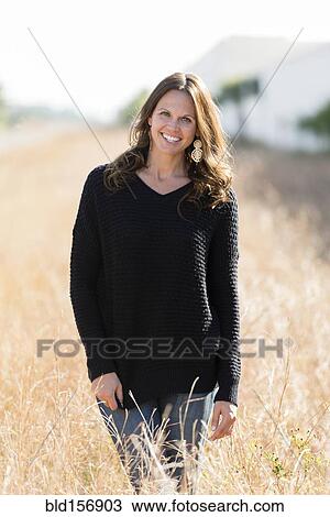 Caucasian woman smiling in tall grass View Large Photo Image Stock Image - Caucasian woman smiling in tall grass. Fotosearch