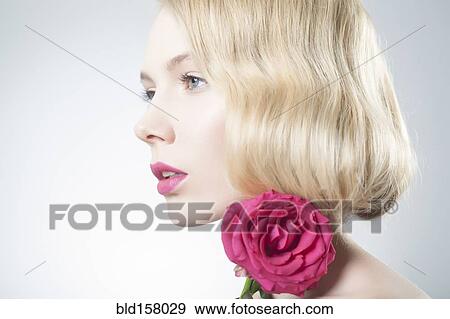 Caucasian woman with pink lipstick holding matching flower View Large Photo Image Stock Photo - Caucasian woman with pink lipstick holding matching flower. Fotosearch