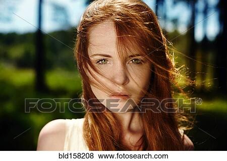 Stock Photo - Caucasian woman with red hair in wind. Fotosearch