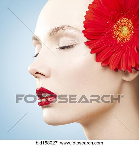 Caucasian woman with red lipstick wearing matching flower View Large Photo Image Stock Photo - Caucasian woman with red lipstick wearing matching flower. Fotosearch