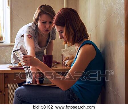 Caucasian women reading magazine at table View Large Photo Image Stock Image - Caucasian women reading magazine at table. Fotosearch