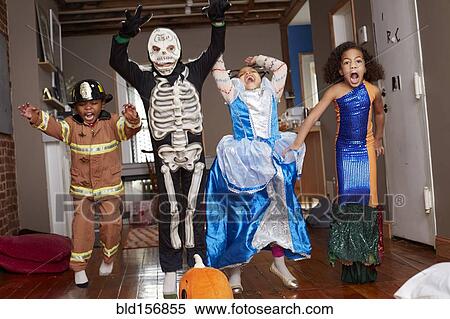 Stock Photography - Children in Halloween costumes jumping for joy. Fotosearch