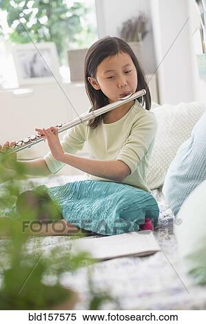 Chinese girl practicing flute on bed View Large Photo Image Stock Photography - Chinese girl practicing flute on bed. Fotosearch