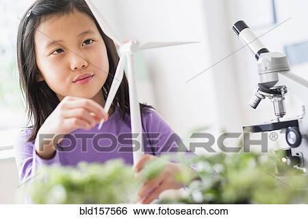 Stock Photograph - Chinese student examining model wind turbine in science lab. Fotosearch
