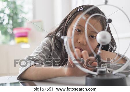 Stock Image - Chinese student examining molecular model. Fotosearch
