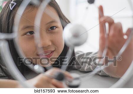Stock Image - Chinese student examining molecular model. Fotosearch