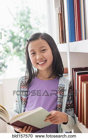 Chinese student reading book near library bookcase View Large Photo Image Stock Image - Chinese student reading book near library bookcase. Fotosearch