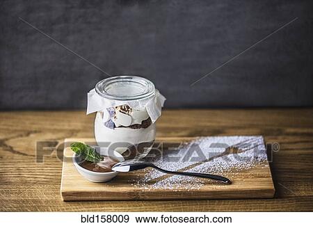 Stock Photo - Chocolate parfait dessert with spoon and powdered sugar fork outline. Fotosearch