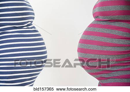 Stock Photography - Close up midsection profiles of stomachs of pregnant women. Fotosearch
