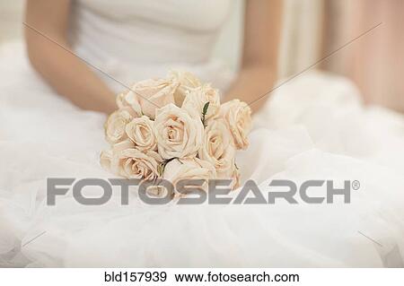 Stock Photo - Close up of bride holding bouquet of flowers. Fotosearch