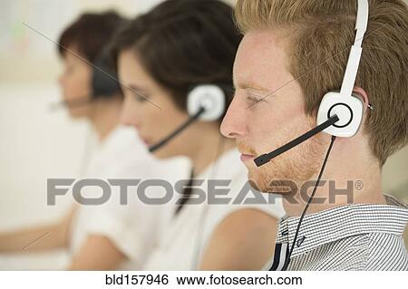 Stock Photograph - Close up of business people wearing headsets. Fotosearch