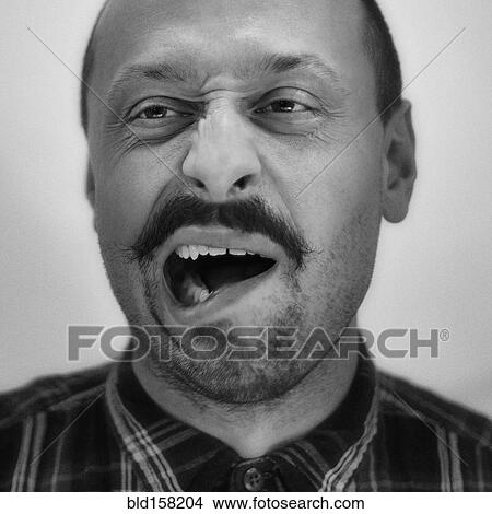 Picture - Close up of Caucasian man grimacing. Fotosearch