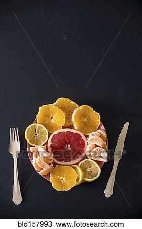 Stock Image - Close up of citrus fruit plate. Fotosearch