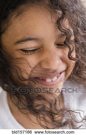 Stock Photograph - Close up of face of smiling mixed race girl. Fotosearch
