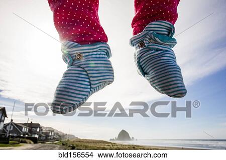 Picture - Close up of feet of Caucasian baby hovering over beach. Fotosearch