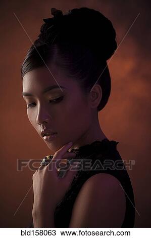 Stock Image - Close up of glamorous woman looking down. Fotosearch