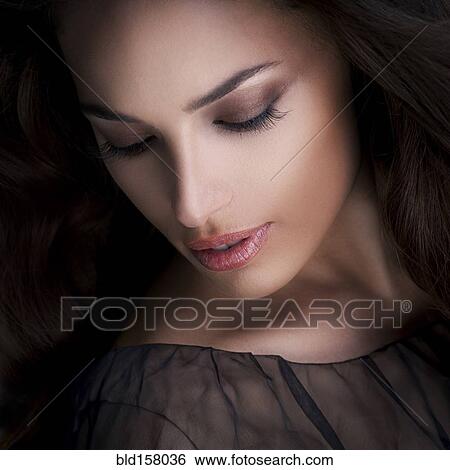 Stock Photograph - Close up of glamorous woman looking down. Fotosearch