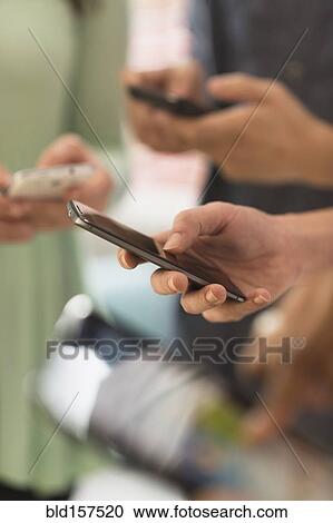 Close up of hands of people texting with cell phones View Large Photo Image Stock Image - Close up of hands of people texting with cell phones. Fotosearch