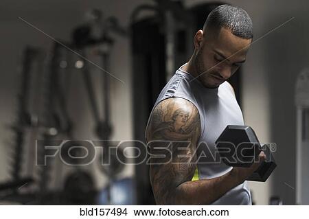 Close up of Hispanic man lifting weights in gym View Large Photo Image Picture - Close up of Hispanic man lifting weights in gym. Fotosearch