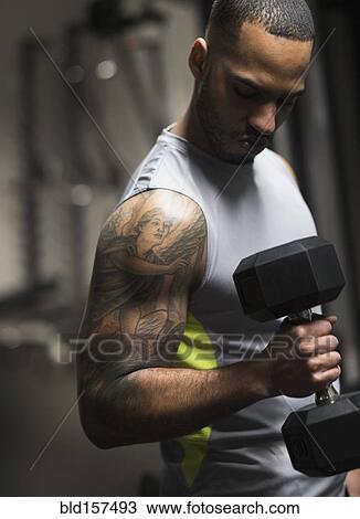 Close up of Hispanic man lifting weights in gym View Large Photo Image Stock Image - Close up of Hispanic man lifting weights in gym. Fotosearch