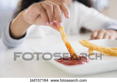 Close up of mixed race girl eating french fries View Large Photo Image Picture - Close up of mixed race girl eating french fries. Fotosearch