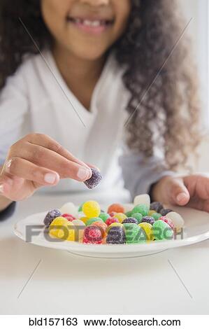 Close up of mixed race girl eating gumdrops View Large Photo Image Stock Image - Close up of mixed race girl eating gumdrops. Fotosearch