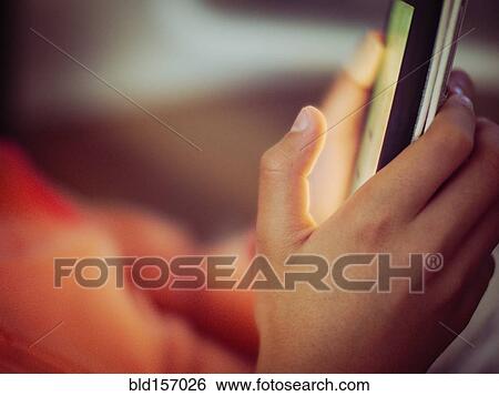 Stock Photograph - Close up of mixed race girl using cell phone. Fotosearch