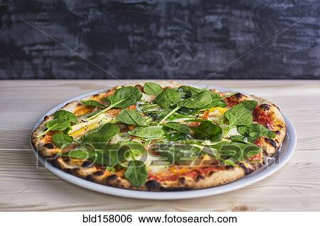 Stock Photograph - Close up of pizza with fresh spinach. Fotosearch