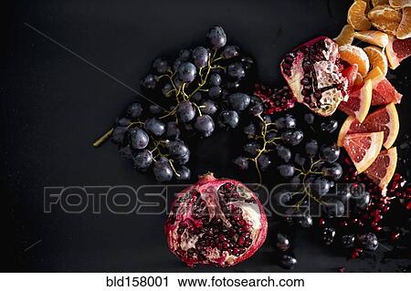 Stock Image - Close up of pomegranates and grapes. Fotosearch