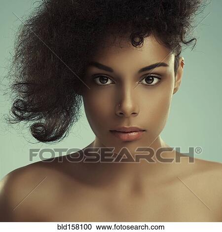 Stock Image - Close up of serious curly-haired woman. Fotosearch