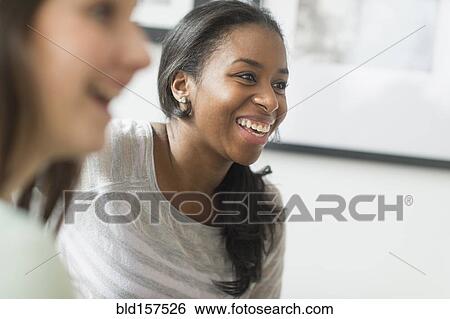 Stock Photograph - Close up of smiling women laughing. Fotosearch