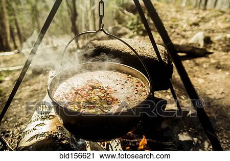Stock Image - Close up of soup cooking over campfire. Fotosearch