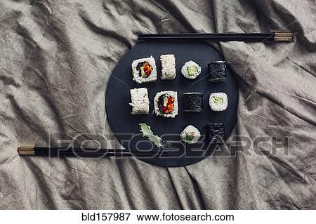 Stock Photo - Close up of sushi platter with chopsticks in bed. Fotosearch