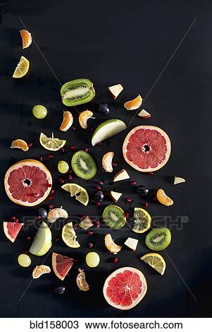 Stock Image - Close up of variety of sliced fruit. Fotosearch