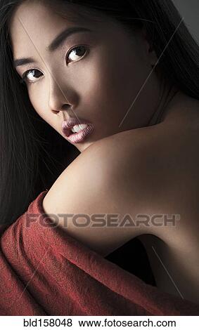 Stock Photo - Close up of woman looking over her shoulder. Fotosearch