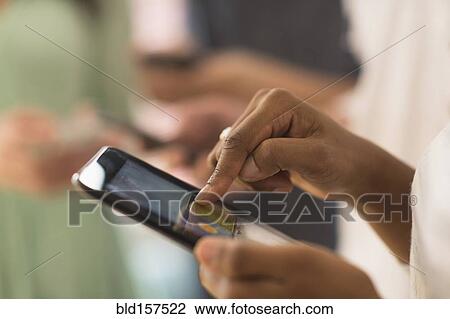 Stock Image - Close up of woman using cell phone touch screen. Fotosearch