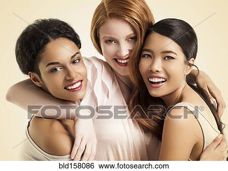 Stock Photograph - Close up of women smiling and hugging. Fotosearch