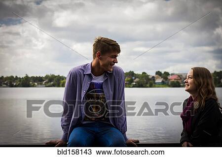Stock Image - Couple talking at waterfront. Fotosearch