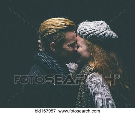 Couple wearing warm clothing kissing View Large Photo Image Stock Photo - Couple wearing warm clothing kissing. Fotosearch