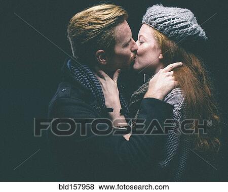 Couple wearing warm clothing kissing View Large Photo Image Stock Photo - Couple wearing warm clothing kissing. Fotosearch