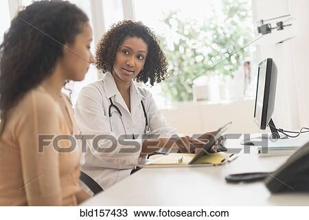 Doctor and patient using digital tablet in office View Large Photo Image Stock Image - Doctor and patient using digital tablet in office. Fotosearch